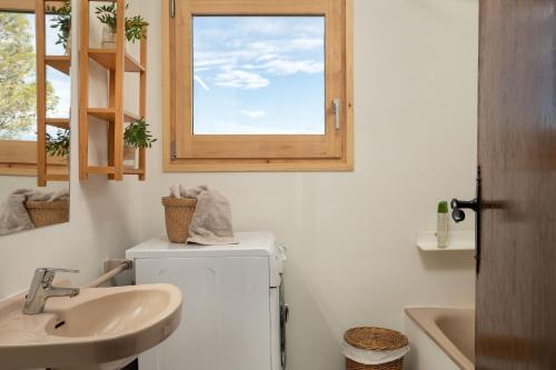 uma casa de banho com um lavatório, um WC e uma janela. em Flateli Begur Muntanya em Begur