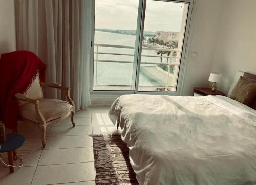 a bedroom with a bed and a large window at Beautiful Apartement with Lakeview in Tunis