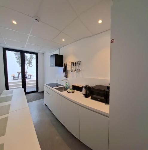 a kitchen with white cabinets and a counter top at Huis ALNA 5 in Mechelen