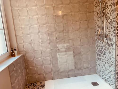 een badkamer met een douche en een tegelwand bij Chez Hab - HyperCentre de Blois in Blois