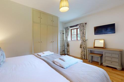 1 dormitorio con cama blanca y escritorio en Birch Cleave Stable Simonsbath, en Simonsbath
