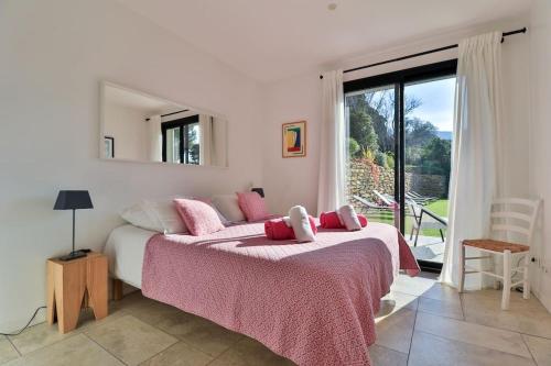une chambre avec un grand lit et une grande fenêtre dans l'établissement Villa Mita, à Cassis