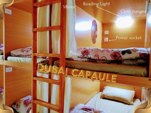 um quarto com 2 beliches e uma escada em Dubai POD Capsule Hostel Near Sharaf DG & Burjuman Metro Station no Dubai
