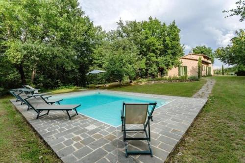 a swimming pool with several chairs and a table at Casa Ilenia in Marciano