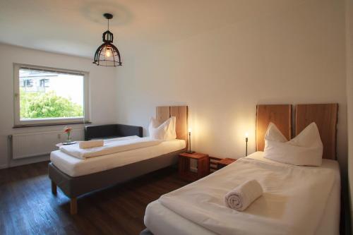 ハノーファーにあるMesse Apartment Hannoverのベッド2台と窓が備わるホテルルームです。