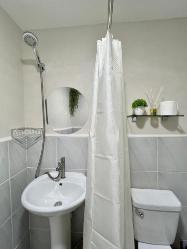 a white bathroom with a sink and a mirror at Condo in Lapu-Lapu City in Lapu Lapu City