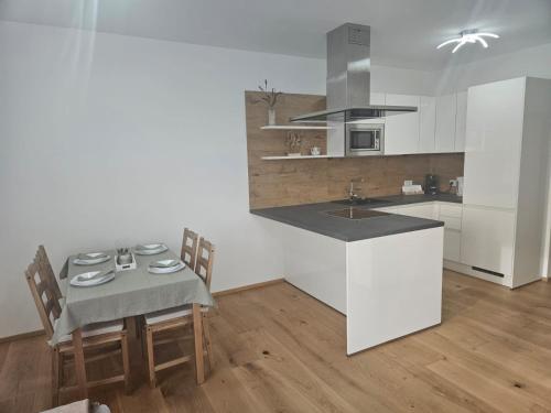 een keuken met een tafel en stoelen en een wastafel bij Apartamente Rognean in Wölfnitz
