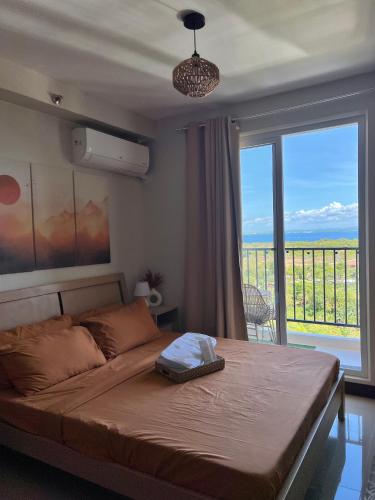 a bedroom with a large bed with a large window at Condo in Lapu-Lapu City in Lapu Lapu City