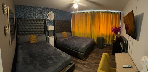 - une chambre avec 2 lits, une table et un bureau dans l'établissement The Village Inn Hotel, à Milwaukee