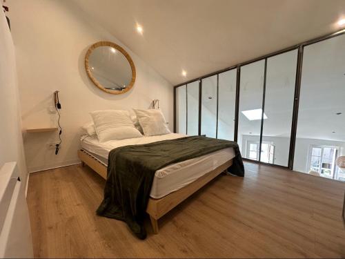 1 dormitorio con 1 cama con espejo en la pared en Charmant Loft moderne au coeur de Hyères, en Hyères