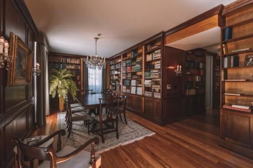 een eetkamer met een tafel en boekenplanken bij VILLA QUINTA TORRINHA Rooms in Funchal