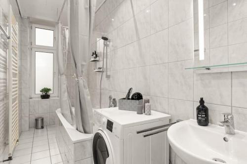 y baño blanco con lavabo y lavadora. en Zentrales Apartment – 2 Boxspringbetten – Netflix, en Kassel