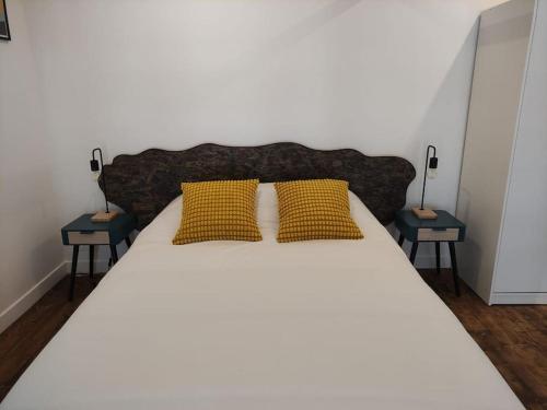 a large bed with two yellow pillows on it at ღ Le Loft • Spacieux, Situé au cœur de Douai in Douai
