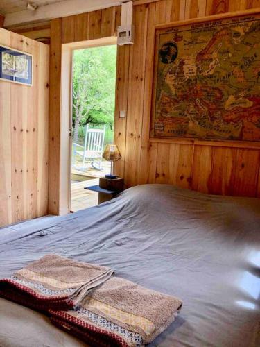 - une chambre avec un lit et une carte murale dans l'établissement Maison bois tout confort proche du lac et de l'océan, à Hourtin
