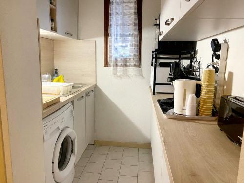 eine Küche mit einer Waschmaschine und einem Waschbecken in der Unterkunft Pavillon indépendant pour 6 personnes dans une résidence sécurisée avec piscine in Valras-Plage