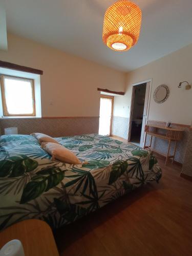 une chambre avec un lit et un lustre dans l'établissement Chambres d'hôtes La Roche, à Saint-Hilaire-des-Landes