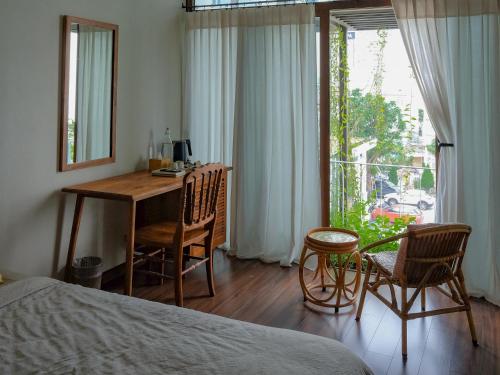 a bedroom with a desk and chairs and a bed at Nhà bình Homestay in Da Nang