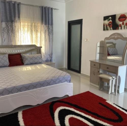 1 dormitorio con cama, tocador y espejo en PARADISE VIEW #73, en Banjul