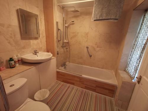 a bathroom with a toilet and a sink and a shower at Beautiful Airbnb with Ensuite Rooms in Shenley Church End