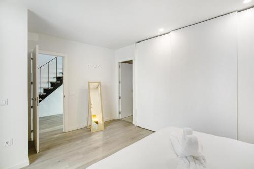 een witte kamer met een bed en een trap bij Wonderful penthouse city and beach in Las Palmas de Gran Canaria