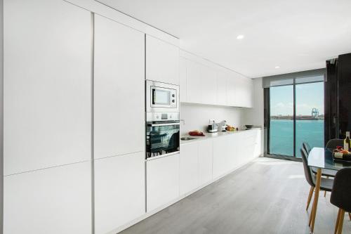 a kitchen with white cabinets and a table and a window at Wonderful penthouse city and beach in Las Palmas de Gran Canaria