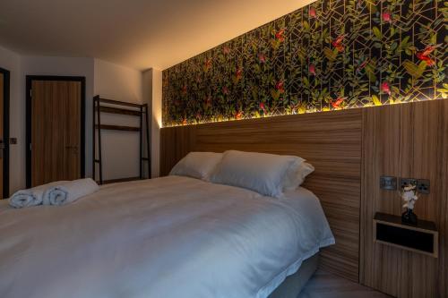 a bedroom with a large bed with a painting on the wall at Hotel No.9 in Derry Londonderry