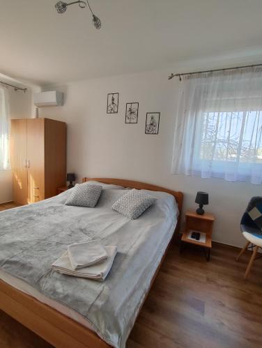 ein Schlafzimmer mit einem Bett, einem Stuhl und einem Fenster in der Unterkunft Hegin Exclusiv Home in Budapest