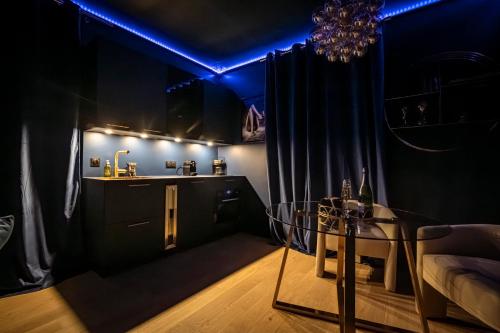 a black room with a glass table and blue lights at Casa Love - Love Room in Quincy-Voisins