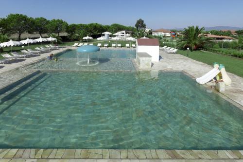a large swimming pool with chairs and a slide at Fattoria Maremmana in Marina di Grosseto