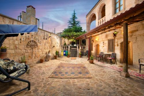 an outdoor patio with a rug on the ground at PERİ CAVE KONAK in Nevsehir