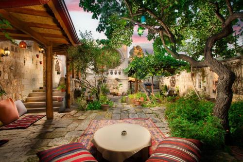 a patio with a table and a tree at PERİ CAVE KONAK in Nevsehir