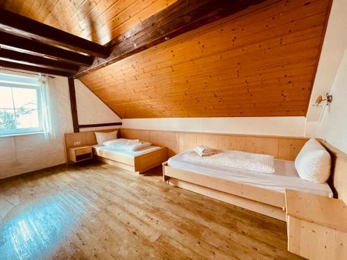 ルストにあるGästehaus Spothのベッド2台が備わる木製の天井の客室です。