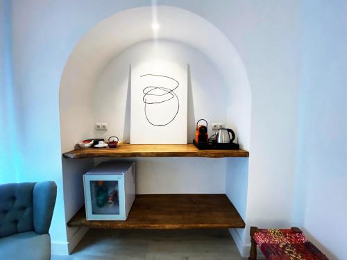 a room with a shelf with a picture and a blue couch at Hotel Alamo in Alicante