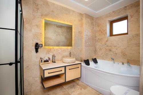 a bathroom with a tub and a toilet and a sink at Acer Living Home in Ortahisar