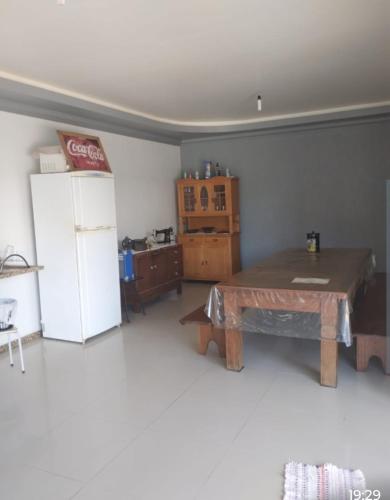 - un salon avec une table et un réfrigérateur dans l'établissement Pousada Margareth Nobre, à Pântano Grande