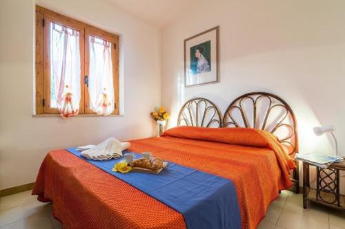 a bedroom with a bed with orange sheets and a tray on it at Wunderschöne Ferienwohnung in Cala Gonone mit Grill und Garten und Meerblick und Strand in der Nähe in Cala Gonone