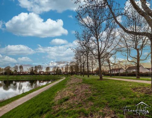un chemin à travers un parc arboré et un étang dans l'établissement Marvel House - Disneyland 5min, Private Parking, Terrace, à Magny-le-Hongre