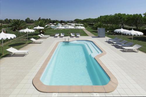 a swimming pool with lounge chairs and umbrellas at Fattoria Maremmana in Marina di Grosseto