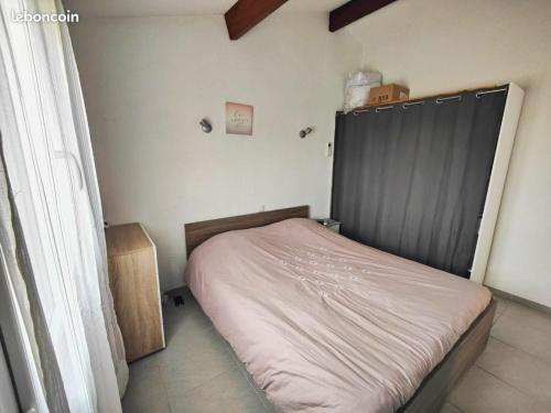 - une petite chambre avec un lit doté d'une tête de lit grise dans l'établissement Les Coralines - Jolie villa de vacances - Piscine - Wifi - Clim, à Saint-Cyprien