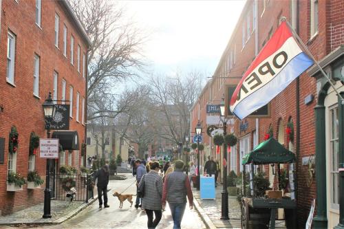 a group of people walking down a street with dogs at Heart of Downtown Newburyport Urban Loft Living in Newburyport