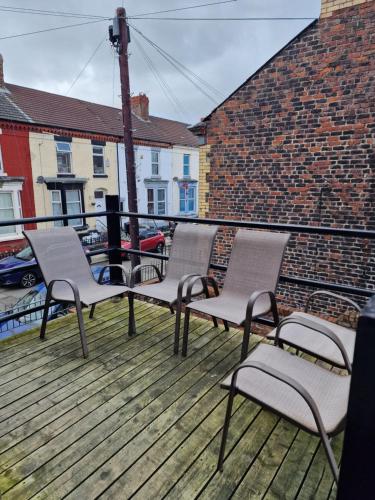 três cadeiras sentadas no topo de um deque em Beautiful Double Bedroom em Liverpool