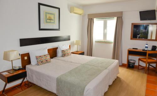 a hotel room with a large bed and a window at LagosMar Story Hotel in Lagos