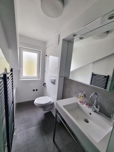 a bathroom with a white sink and a toilet at Hotel San Antonio in Podstrana