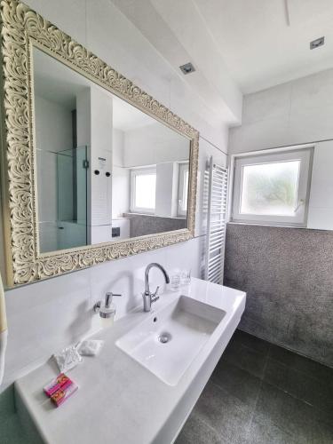 a bathroom with a white sink and a mirror at Hotel San Antonio in Podstrana