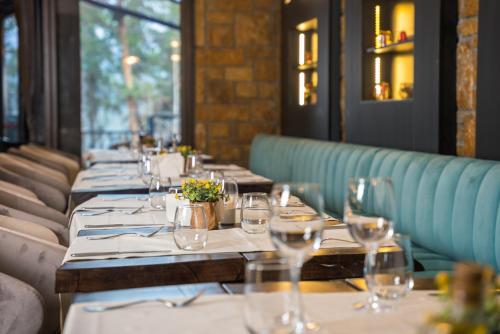 a row of tables in a restaurant with wine glasses at Maxi Park Hotel & Spa in Velingrad