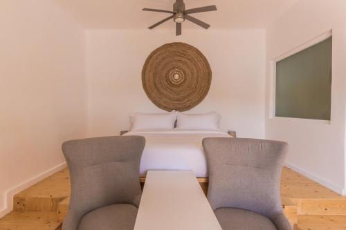 a dining room with a bed with two chairs at SALT SUITES MILOS in Pollonia
