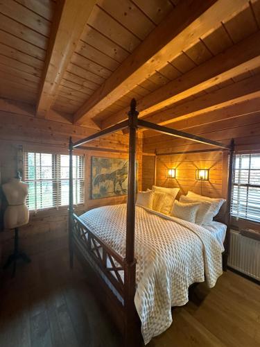 1 dormitorio con 1 cama en una cabaña de madera en EifelChalet Arduina mit Wintergarten und Saunahaus im Naturpark Hohes Venn- Eifel, en Hellenthal