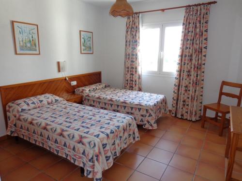 ein Hotelzimmer mit 2 Betten und einem Fenster in der Unterkunft Apartamentos Los Pinares Benet in Santa Eulària des Riu