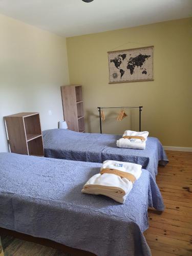 une chambre avec deux lits avec des serviettes dessus dans l'établissement le Moulin de la Raterie, à Charensat