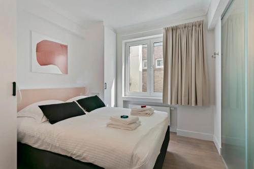 een slaapkamer met een bed met handdoeken erop bij Huswell - Panoramic seaview apartment in 't Zoute in Knokke-Heist